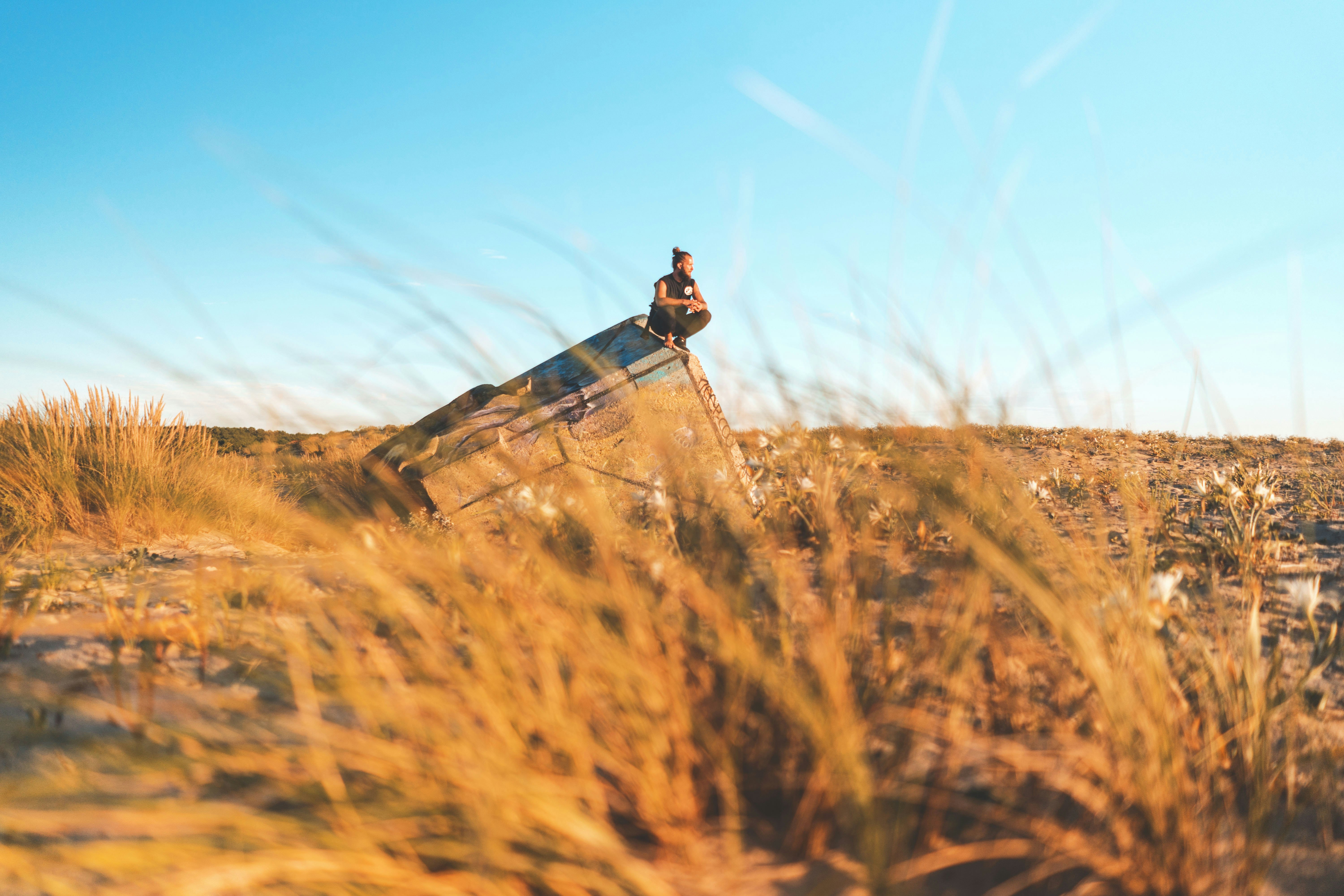 man squat on abandoned cargo on green grass